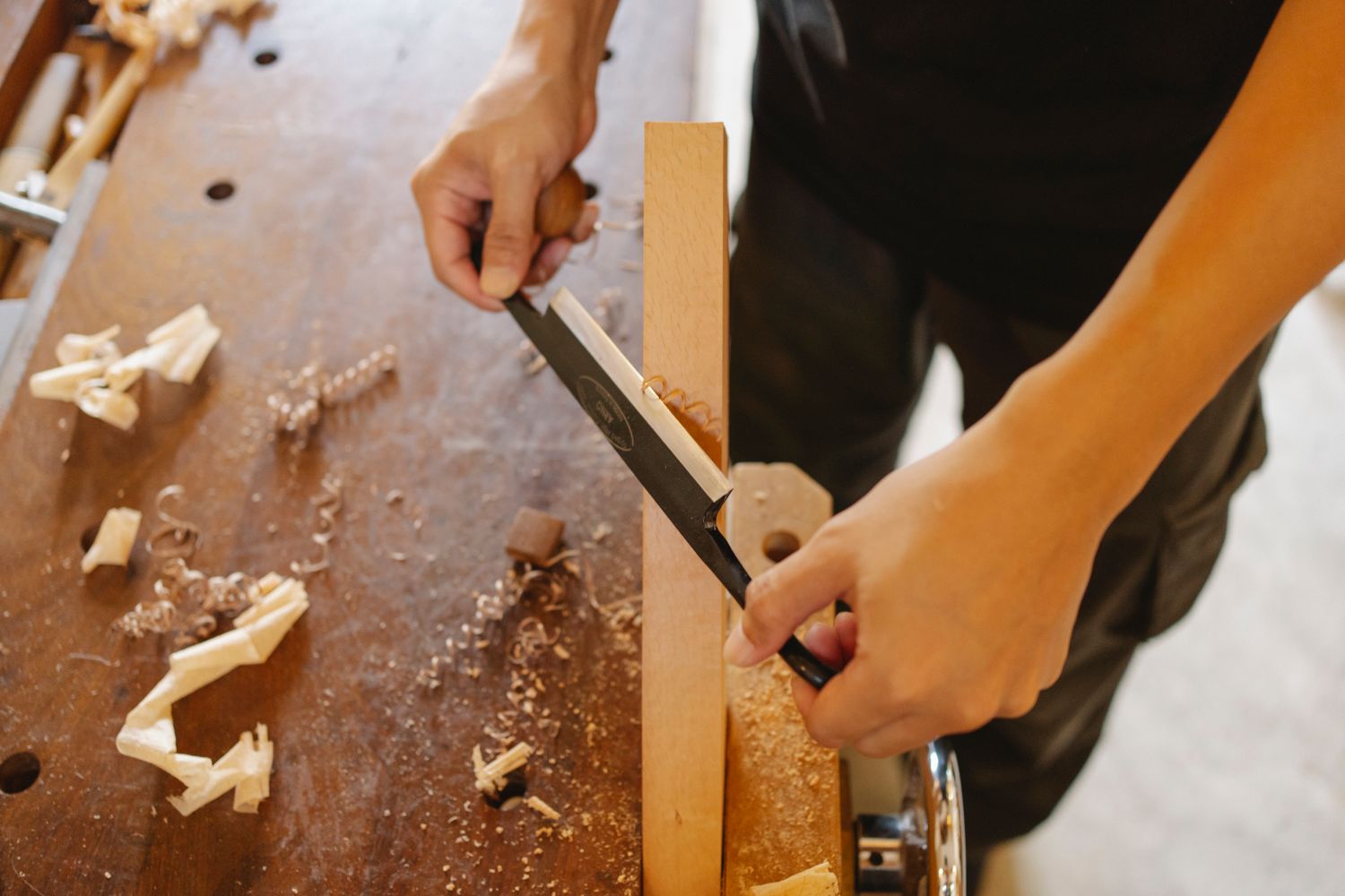 Mains qui scient une pièce de bois